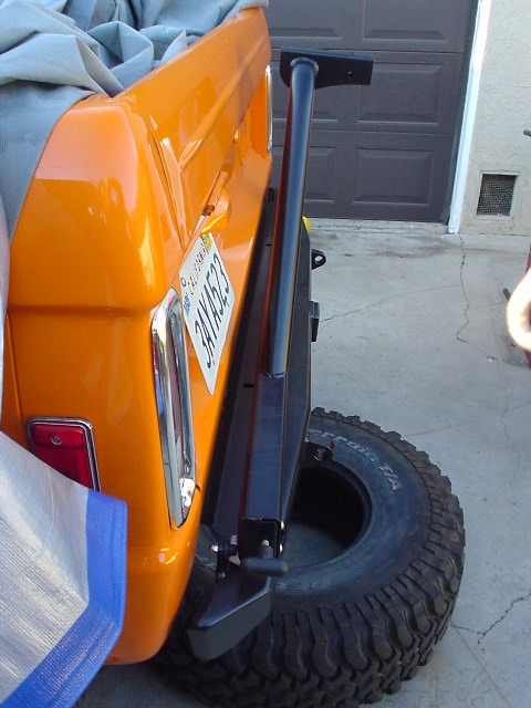 1977 Ford Bronco - Rear view of an orange 1977 Ford Bronco showing its spare tire and California license plate.