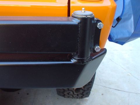 1977 Ford Bronco - The rear corner of an orange 1977 Ford Bronco shows a black aftermarket bumper mount and a portion of the tire.