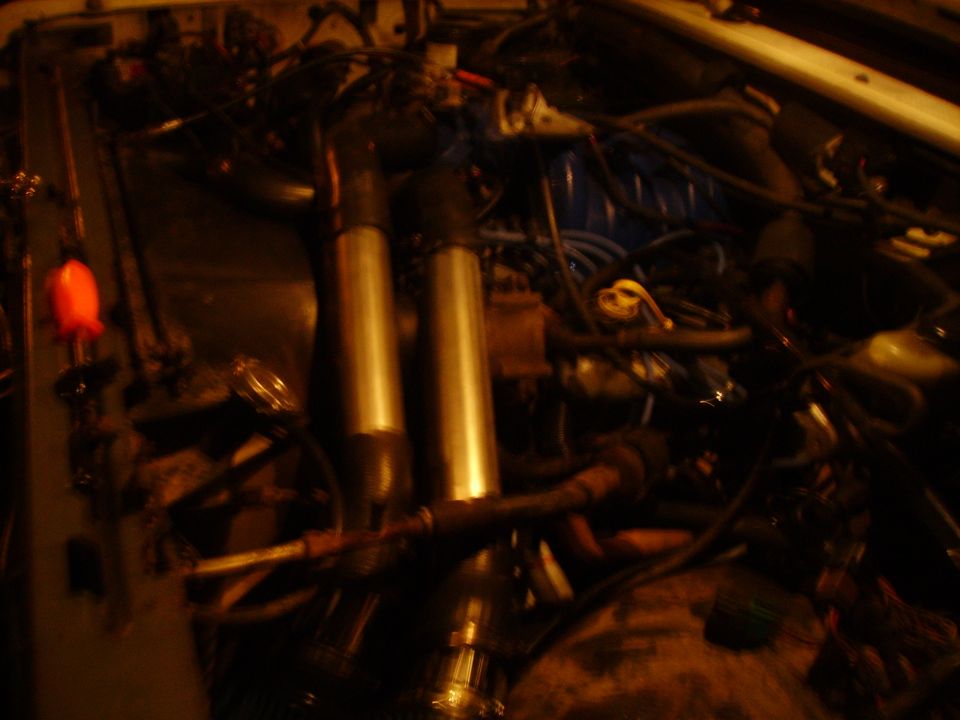 Dimly lit engine bay showing twin shock absorbers and wiring