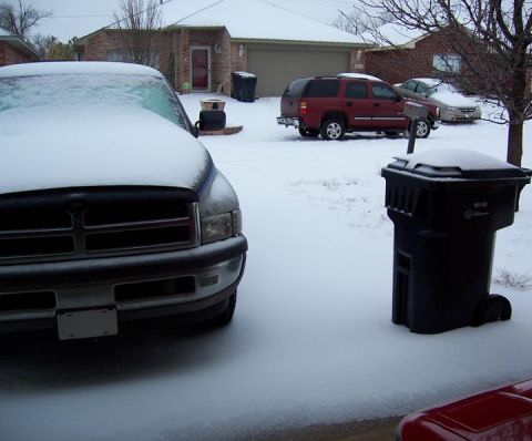 1988 Pontiac Fiero - Multiple vehicles are parked in a snowy driveway on a cloudy day.