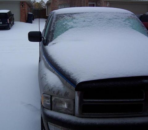 1988 Pontiac Fiero - A pickup truck sits covered in snow, with a second vehicle visible in the background.