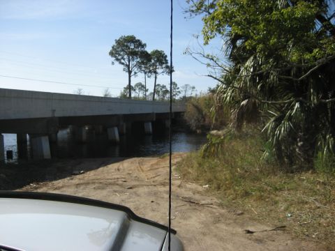 1986 Ford Bronco - View from a vehicle's hood looking towards a bridge and waterway on a sunny day.