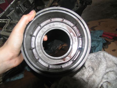 1978 Ford Bronco - A person holds a disassembled transmission part, showing internal components and oil stains.