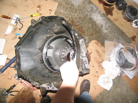 1978 Ford Bronco - A person is working on a disassembled automatic transmission with various tools and parts laid out on cardboard.