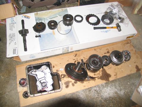 1978 Ford Bronco - Disassembled transmission components are arranged on cardboard for inspection or repair.