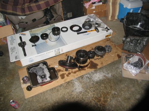 1978 Ford Bronco - Various components of an automatic transmission are disassembled and spread out on the floor for inspection or repair.