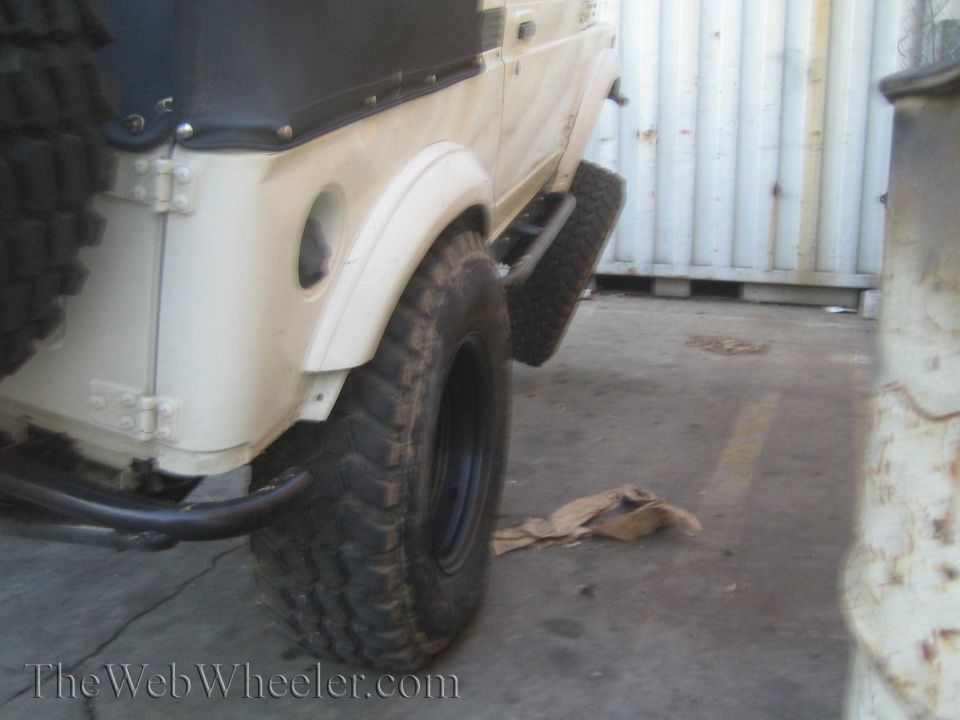 1987 Suzuki Samurai rear quarter panel, soft top, and large off-road tire