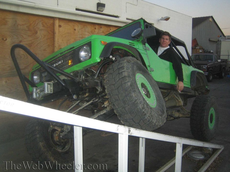 Green 1987 Suzuki Samurai on RTI ramp with large tires