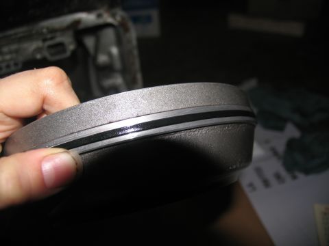 1978 Ford Bronco - Metal transmission part with a seal ring being held by a hand.