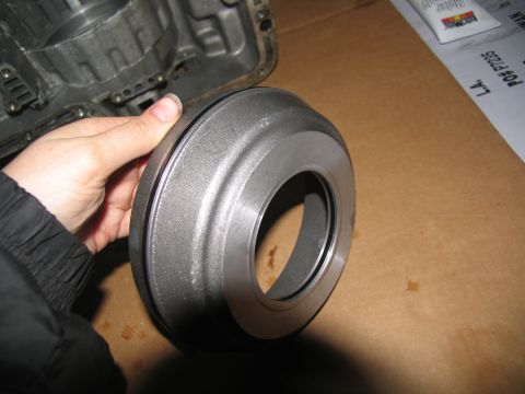 1978 Ford Bronco - A metal transmission part is held for inspection, with a transmission casing visible in the background.