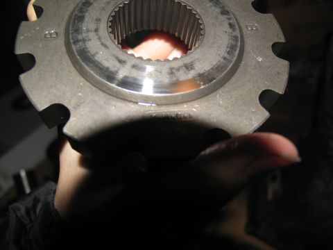 1978 Ford Bronco - Close-up of a metal gear, likely a transmission component, held by a hand.