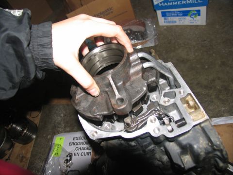 1978 Ford Bronco - Close-up of a person holding a transmission part during a rebuild.