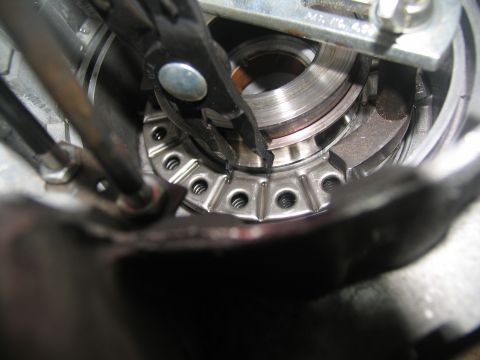 1978 Ford Bronco - Mechanic uses pliers to manipulate a part within a vehicle's transmission assembly.