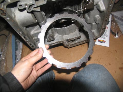 1978 Ford Bronco - Clutch plate held up to transmission case during rebuild. Assembly lube tube in background.