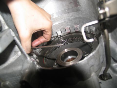 1978 Ford Bronco - Close-up of a hand installing a clutch pack into a transmission during a rebuild.