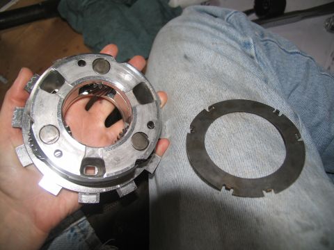 1978 Ford Bronco - A person holds a transmission clutch pack and a separate ring, likely for repair or inspection.