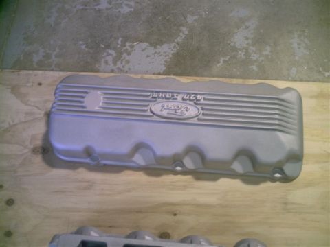 1964 Ford 427 - A silver Ford valve cover with embossed text and logo is shown on a wooden surface.