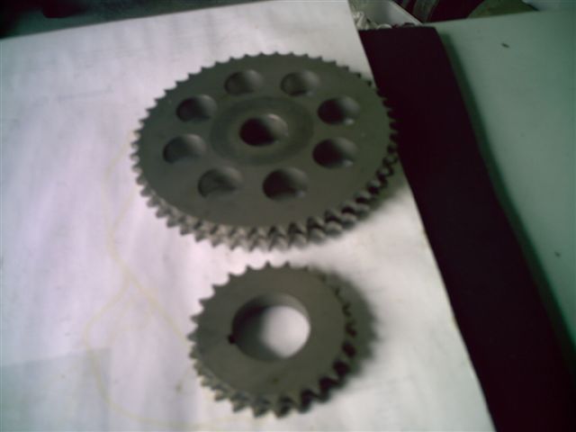 Two metal gears, one larger than the other, on a white surface