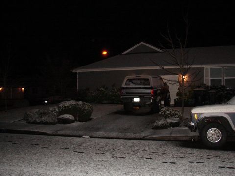 1996 Ford Bronco - A Ford Bronco is parked in a snowy driveway at night, with another vehicle in the foreground.