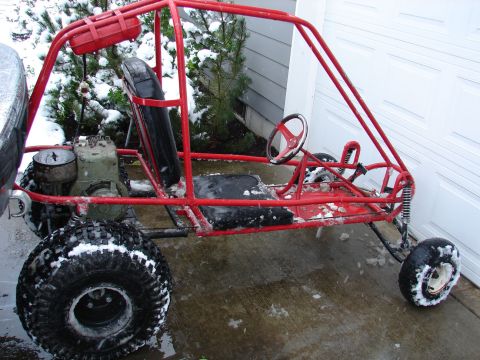 1996 Ford Bronco - A red buggy with a roll cage and off-road tires sits in the snow.