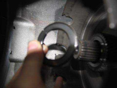 1978 Ford Bronco - Close-up of a transmission component being held by a hand, with a splined shaft visible.