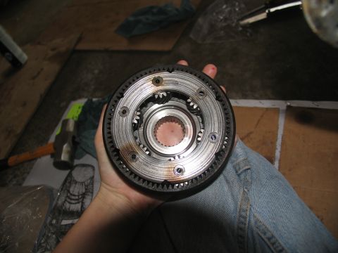 1978 Ford Bronco - A planetary gear set is held in a hand, with a hammer visible in the background.