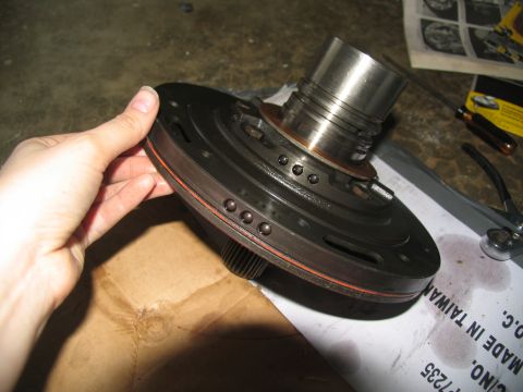 1978 Ford Bronco - A transmission pump assembly is shown, with tools and a partially obscured document in the background.