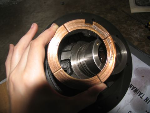 1978 Ford Bronco - Close-up of a hand holding a transmission component, possibly a bearing cage.