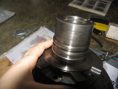 1978 Ford Bronco - A hand holds a worn metal transmission part, likely during a rebuild process.