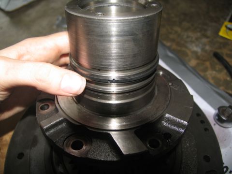 1978 Ford Bronco - Close-up of a hand adjusting seals on a metal component, likely from a vehicle's transmission.