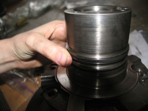 1978 Ford Bronco - A hand inspects a metal transmission part, showing wear and damage.