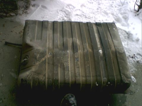 1973 Ford Ranchero - A used fuel tank sits outdoors in the snow, showing signs of wear and tear.