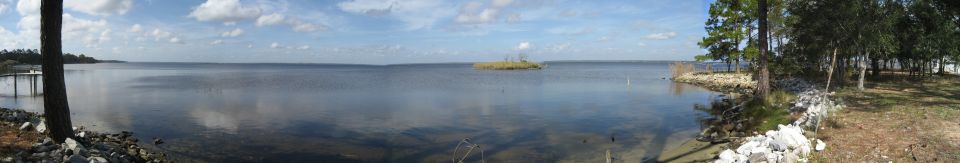 Panoramic lake scene with an island and trees on the shore