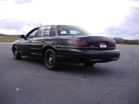 2001 Ford Crown Victoria - Rear view of a black 2001 Ford Crown Victoria with steel wheels.