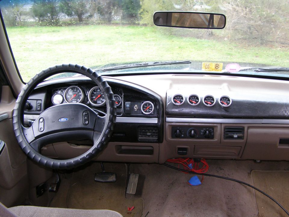 Tan Ford truck interior dash with steering wheel and added gauge pod