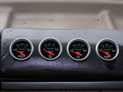 1993 Ford Bronco - A close-up shows four aftermarket gauges installed in a vehicle's dashboard.