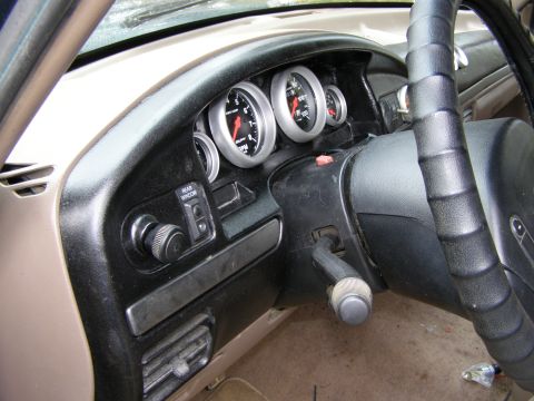 1993 Ford Bronco - Interior view of a vehicle's dashboard aftermarket gauges and a rear window control.