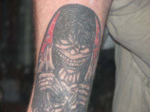 1991 Ford Bronco - A tattoo of a grinning skull with red accents is visible on an arm. The image also contains a SuperMotors watermark.