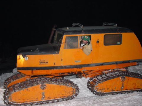 1986 Ford Bronco - A man drives a vintage Tucker Sno-Cat vehicle through a snowy landscape at night.
