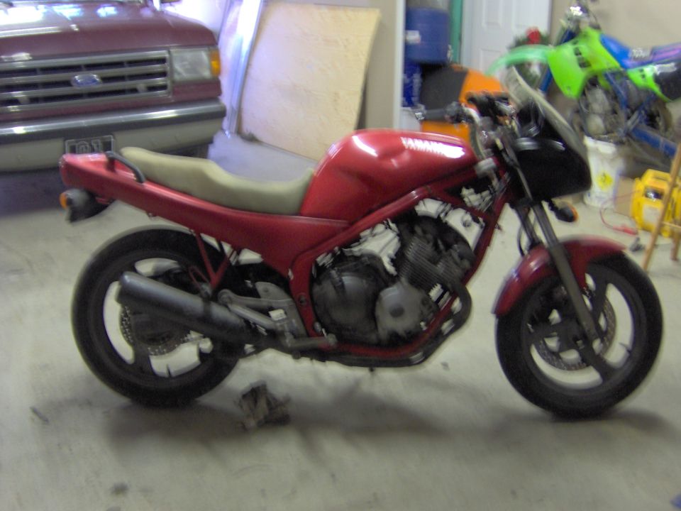 Red Yamaha naked motorcycle, side view, in a garage