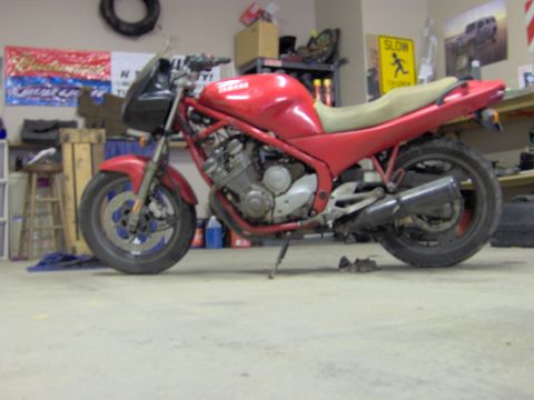 1993 Yamaha Seca II - A red 1993 Yamaha Seca II motorcycle is seen from the side in a garage setting.