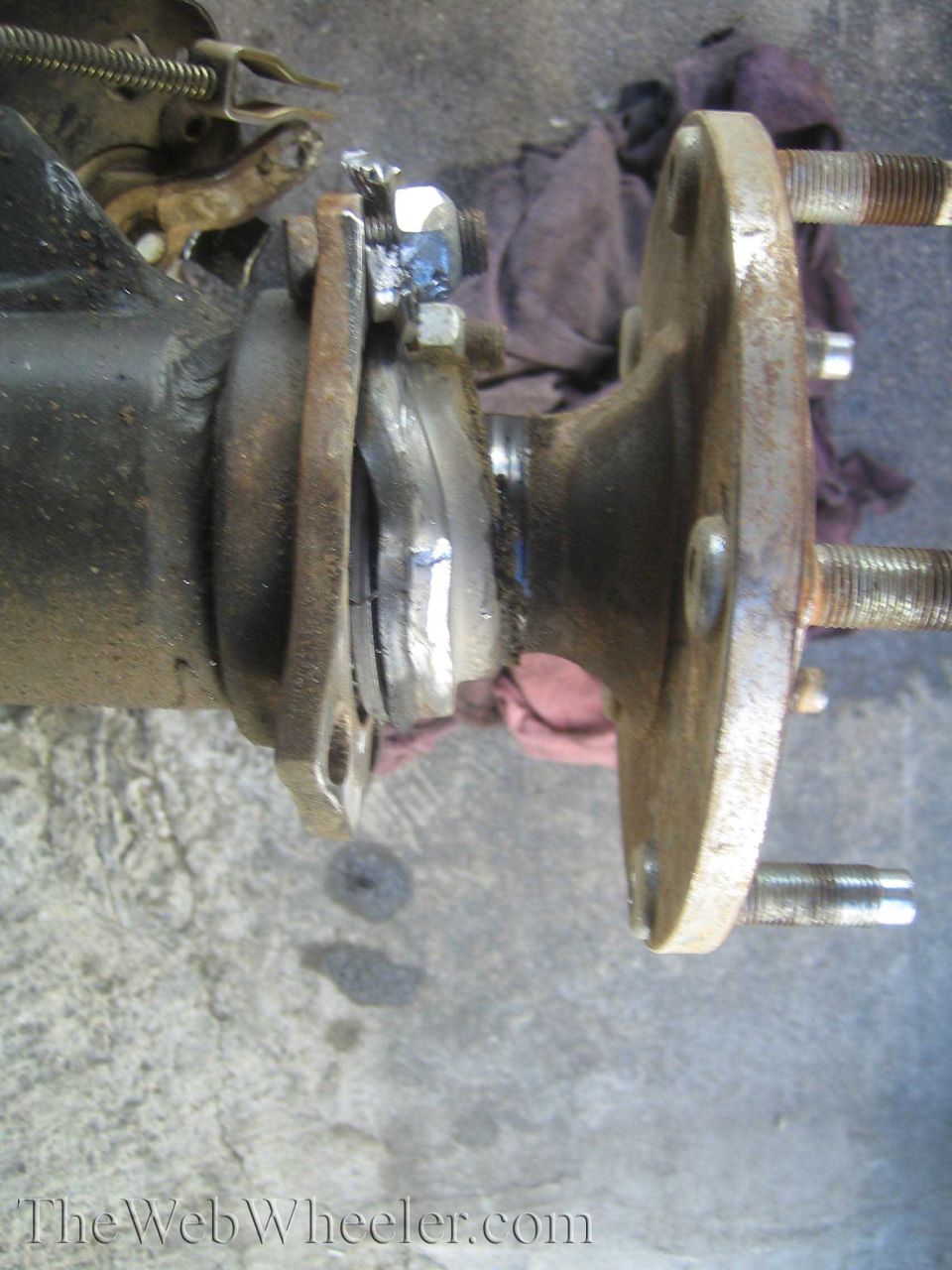 Close-up of axle bearing and hub flange with wheel studs during service
