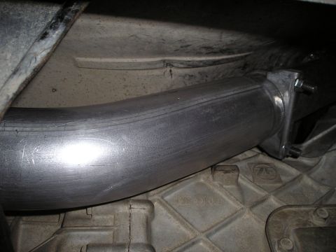 1997 Ford F-250 - A new exhaust pipe section is installed on the underside of a vehicle, connecting to existing components.