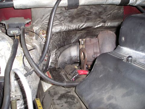 1997 Ford F-250 - Close-up view of the engine bay, focusing on the turbocharger and associated piping. Some heat shielding is visible.