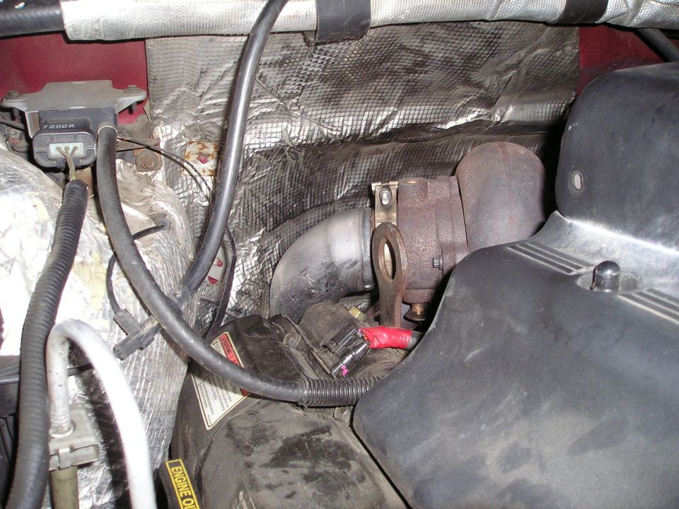 Engine bay with turbocharger and exhaust piping. Visible text: 'ENGINE OIL'