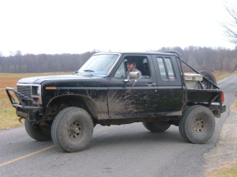 1985 Ford F-150 - This black pickup truck appears to be from the early 1980s, modified for off-road use.