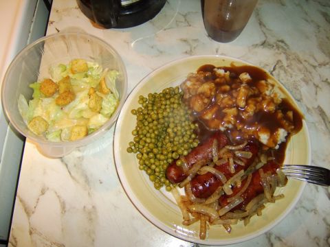 1989 Ford Bronco - A meal consisting of sausages, mashed potatoes with gravy, peas, and a side salad is presented on a table.