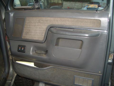 1988 Ford Bronco - Interior door panel detail showing fabric insert, storage pocket, and a small aftermarket switch panel.