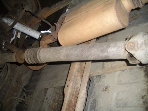 1988 Ford Bronco - A close-up view of the undercarriage reveals the exhaust system and driveshaft, with visible rust on the frame.