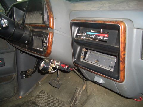 1988 Ford Bronco - Interior view of a 1988 Ford Bronco dashboard, wood grain trim and an aftermarket gauge.